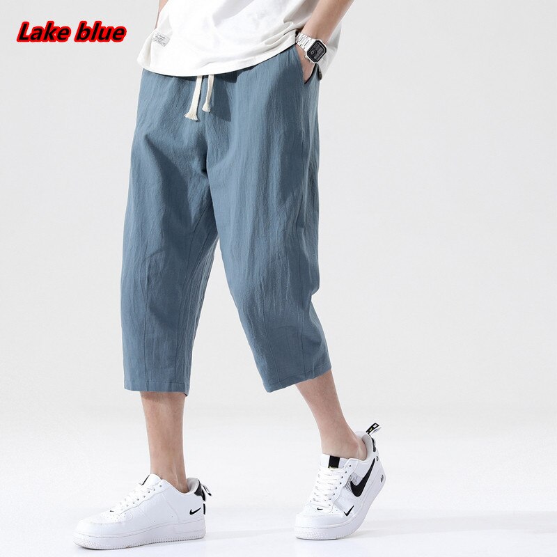 Loose fit 3/4 length mens pants. Features Mid-raise waist,drawstring closure.