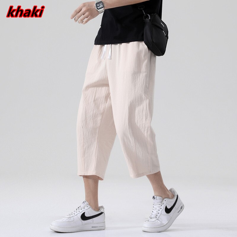 Loose fit 3/4 length mens pants. Features Mid-raise waist,drawstring closure.