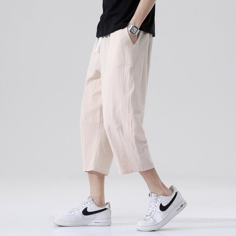 Loose fit 3/4 length mens pants. Features Mid-raise waist,drawstring closure.