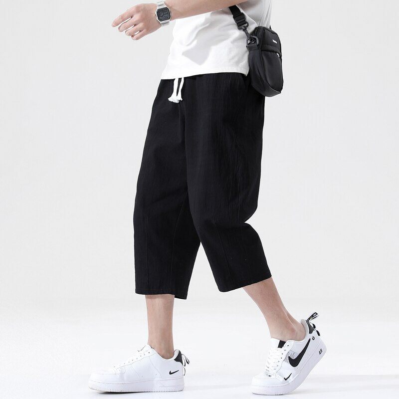 Loose fit 3/4 length mens pants. Features Mid-raise waist,drawstring closure.