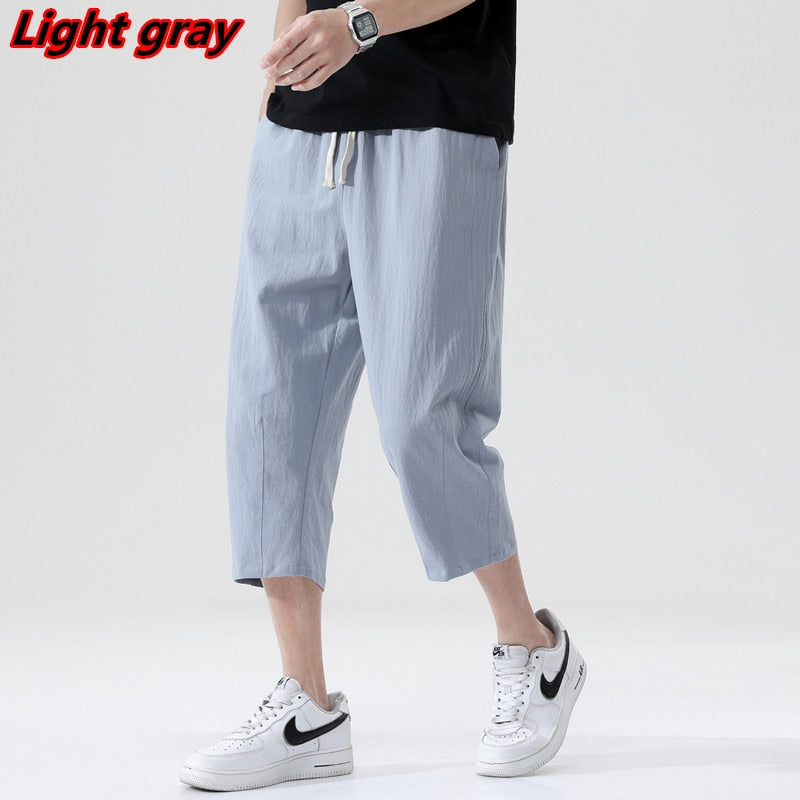 Loose fit 3/4 length mens pants. Features Mid-raise waist,drawstring closure.