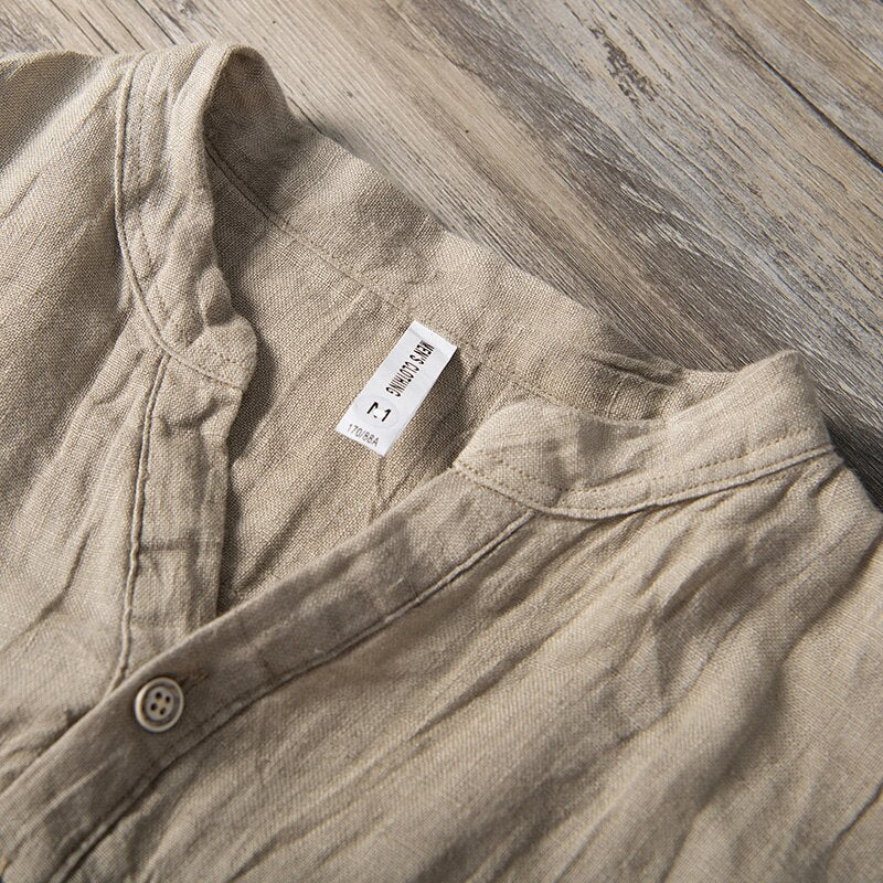 Collar detail of Natural colour Shirt with relaxed fit and short sleeves  with Round stand-up collar V-neck front opening .